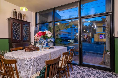 a dining room with a table with flowers on it at Nyonya Maison Boutique Hotel Phuket Old Town in Phuket Town