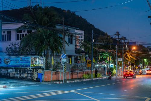 a city street at night with a car driving down the street at Nyonya Maison Boutique Hotel Phuket Old Town in Phuket Town