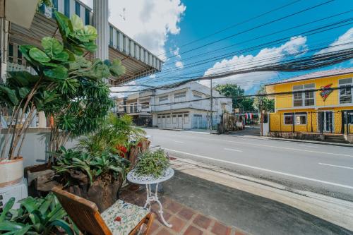 a street with a table and chairs on the side of a road at Nyonya Maison Boutique Hotel Phuket Old Town in Phuket Town