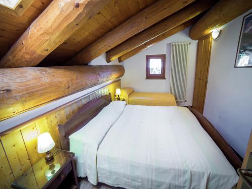 a bedroom with a bed and a wooden ceiling at A Cozy Alpine Retreat in Antey-Saint-André