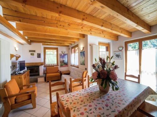 a living room with a table with a vase of flowers at A Cozy Alpine Retreat in Antey-Saint-André