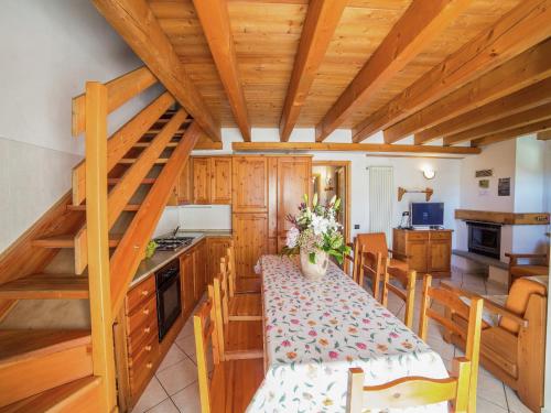 a kitchen and dining room with a wooden ceiling at A Cozy Alpine Retreat in Antey-Saint-André