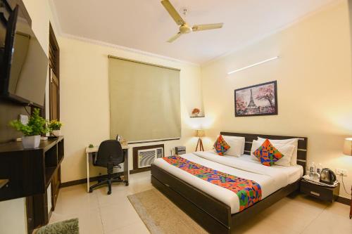 a bedroom with a bed and a desk and a television at FabHotel Golf Luxury in Gurgaon