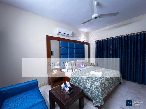 a living room with a bed and a blue couch at Hotel white palace in Karachi