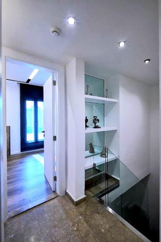 a room with white walls and a hallway with shelves at La Maison De Hamra Hotel Apartments in Beirut
