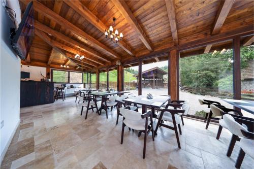 una sala da pranzo con tavoli, sedie e finestre di Branovia a Bran