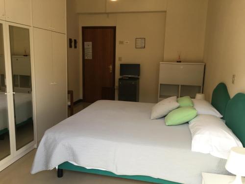 a bedroom with a large white bed with green pillows at G&D Winter Home in Milano Marittima