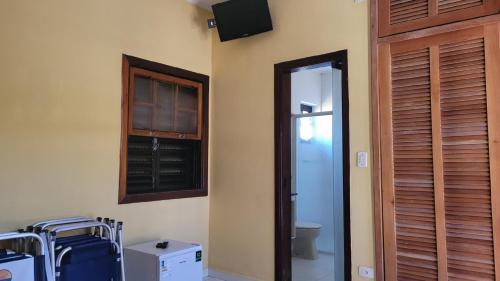 Una habitación con un baño y un televisor en la pared. en PeruíBella Pousada, en Peruíbe