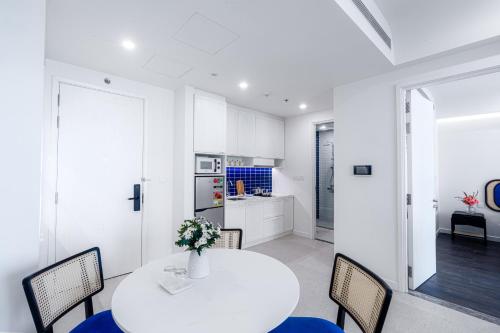 a kitchen and dining room with a white table and chairs at Sole Casa Phu Quoc in Phu Quoc