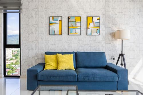 a blue couch with yellow pillows in a living room at Beacon Executive Suite in George Town