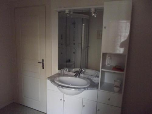 a white bathroom with a sink and a shower at Gite Alize in Dambach-la-Ville