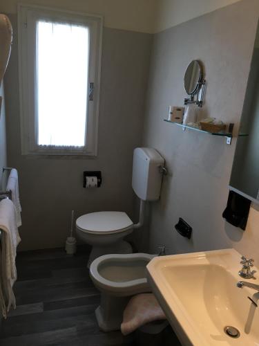 a bathroom with a toilet and a sink and a window at G&D Winter Home in Milano Marittima
