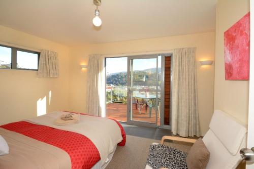 a bedroom with a bed and a view of a patio at Sleep on the Steepest Street in the World! in Dunedin
