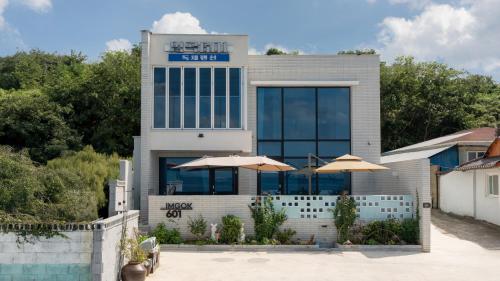 a building with two umbrellas in front of it at pohang imgok601dokchae oceanview pension in Pohang