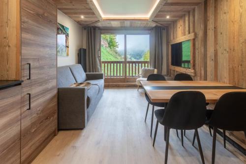 a living room with a table and chairs and a couch at Ermitage 28 in Méribel