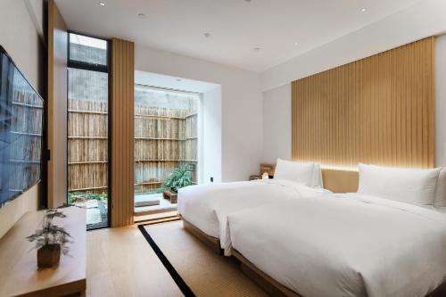 a bedroom with two beds and a large window at 徐州云东境酒店 in Xuzhou