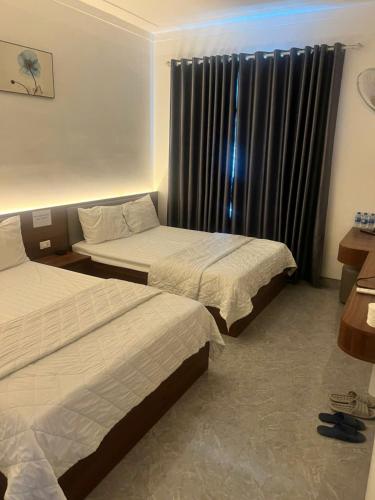 にあるVisip Hotelのベッドが2つと窓があるホテルの部屋