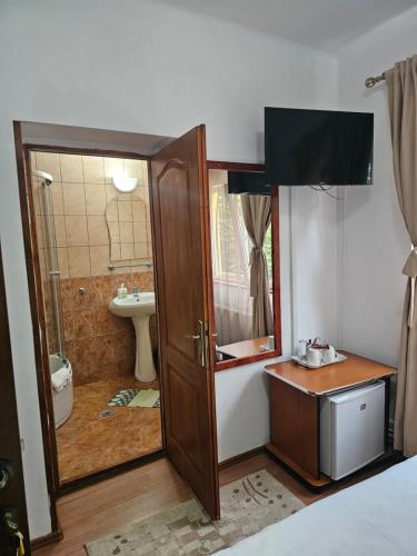 a bathroom with a sink and a toilet and a shower at Foisor Vila in Buşteni