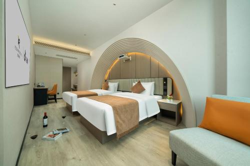 a hotel room with two beds and a chair at Rezen Borui Hotel Guangzhou Tower Sun Yat-sen University Branch in Guangzhou