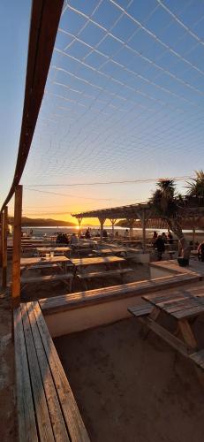 a view of a beach with a bench and a sunset at Sunset retreat caravan with large wrap around decking in Newquay