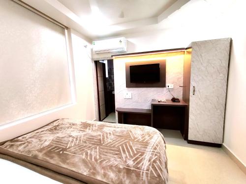 a bedroom with a bed and a sink and a television at Hotel RN Residency - Near Prem Mandir Vrindavan in Vrindāvan