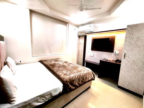 a small bedroom with a bed and a television at Hotel RN Residency - Near Prem Mandir Vrindavan in Vrindāvan