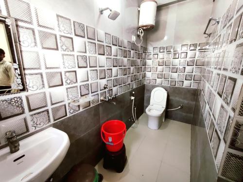 a bathroom with a sink and a toilet and a mirror at Hotel RN Residency - Near Prem Mandir Vrindavan in Vrindāvan