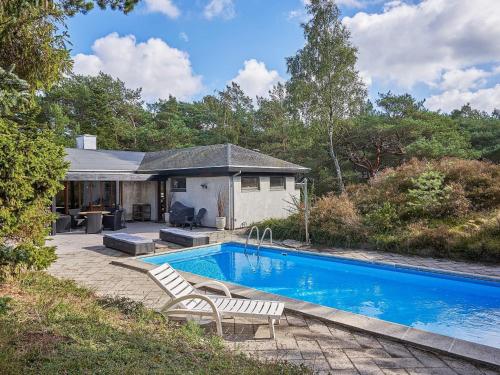 una piscina con due sedie accanto a una casa di 6 person holiday home in Nexø a Neksø
