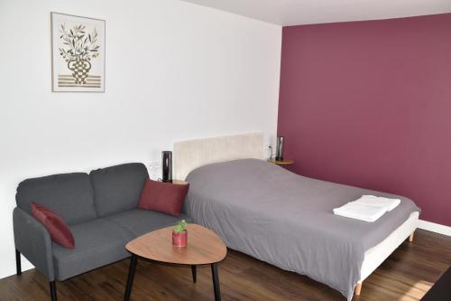 a bedroom with a bed and a couch and a table at Zen Cottage - Centre ville in Brest