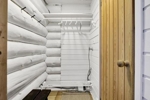 a hallway with white walls and a wooden door at Villa Tundra - Valkea Homes in Pyhätunturi