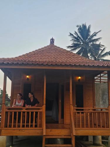 two people standing on the balcony of a house at Arta dani villas in Sidemen