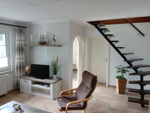 a living room with a chair and a staircase at Ferienhaus Frank in Gellenthin