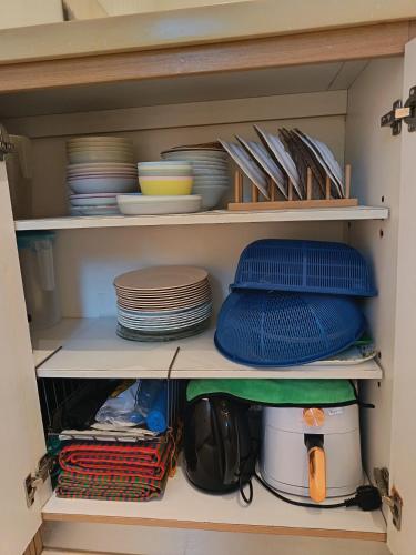 a cabinet filled with plates and bowls and dishes at Zen Clan Homestay 15mins Sepang, KLIA, USIM, Nilai in Kampong Jijan Hilir