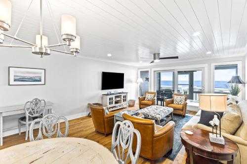 a living room filled with furniture and a flat screen tv at Beach Club Villa 32 - Newly Renovated! Direct Oceanfront in Isle of Palms