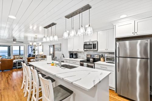 a kitchen with white cabinets and a large kitchen island at Beach Club Villa 32 - Newly Renovated! Direct Oceanfront in Isle of Palms
