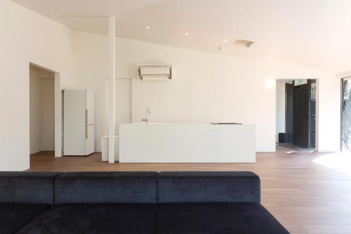 a living room with a couch and a kitchen at Mori no Hanare in Karuizawa