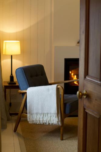 a living room with a chair and a fireplace at Torran Cottage in Kinlochewe