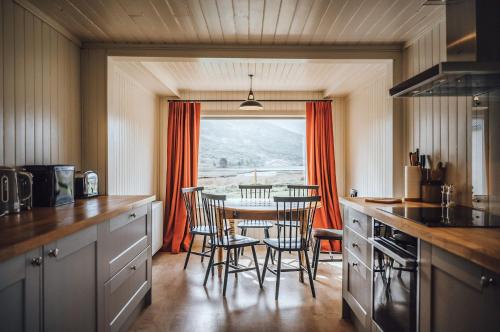 a kitchen with a table and chairs and a window at Torran Cottage in Kinlochewe