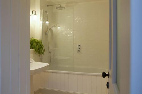 une salle de bain avec une douche, une baignoire et un lavabo dans l'établissement Torran Cottage, à Achnashellach Station