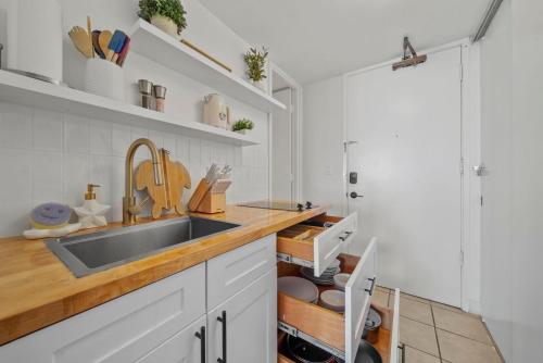 a kitchen with a sink and a counter at Waikiki 30FL Luxury Studio with Majestic Ocean Fireworks in Honolulu