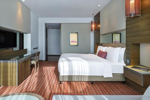 a hotel room with a bed and a flat screen tv at Park Rotana Abu Dhabi in Abu Dhabi
