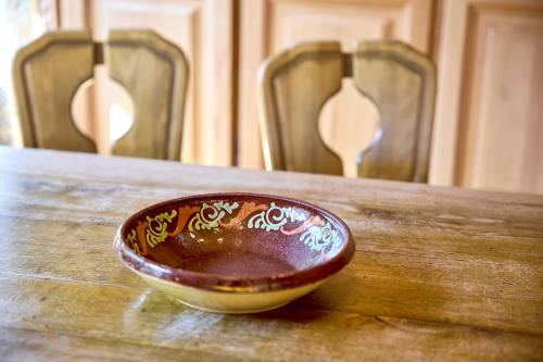 a bowl sitting on top of a wooden table with chairs at Alt Montafon Hotel Appartements by Pferd auf Wolke in Gaschurn