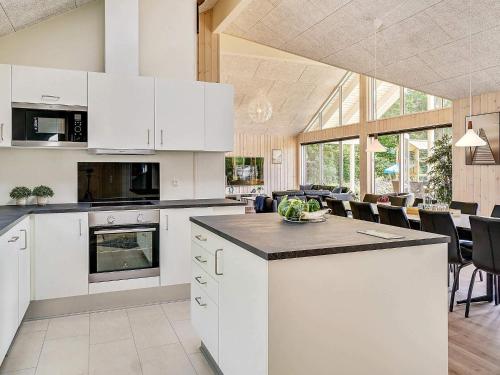 a kitchen with white cabinets and a dining room at Luxury Pool Villa in Vejby - By Traum Ferienwohnungen in Vejby