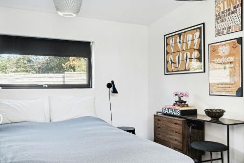 une chambre avec un lit, un bureau et une fenêtre dans l'établissement Indulgence In Architect-Designed House In Vejby, à Vejby Strand