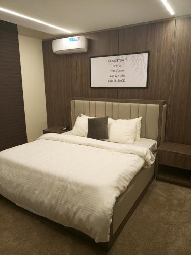 a bedroom with a large bed with white sheets at The Iconic Place in Garki