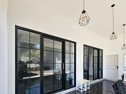 a living room with black windows and a white wall at Dhoriz Homestay Syariah RedPartner at Kampung Inggris Pare in Pare