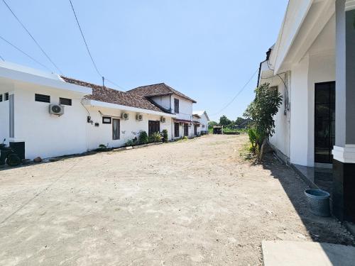 an empty driveway between two white buildings at Dhoriz Homestay Syariah RedPartner at Kampung Inggris Pare in Pare