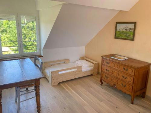 a bedroom with a bed and a desk and a dresser at Family Home In The Alpes Mancelles in Moulins-le-Carbonnel