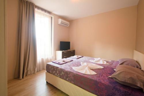 a bedroom with a bed with towels on it at Holiday Village Lozenets in Lozenets