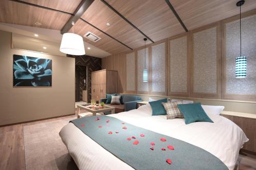 a bedroom with a large bed with red flowers on it at Hotel SWEET SEASON埼玉川越桜の川店 in Kawagoe